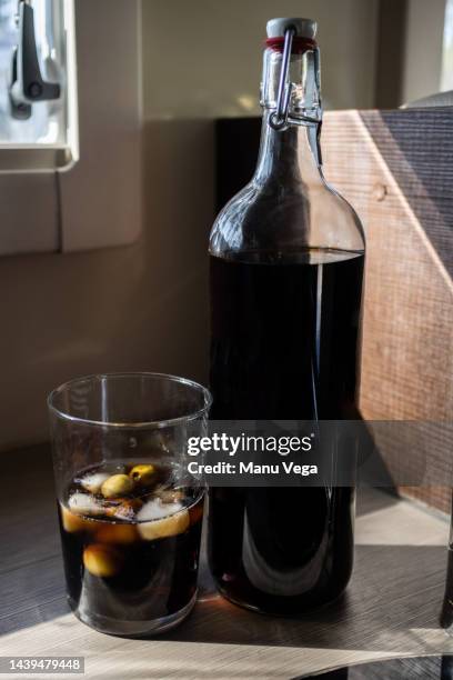 bottle of vermouth on the kitchen counter, served in a glass with ice. - vinho fortificado imagens e fotografias de stock