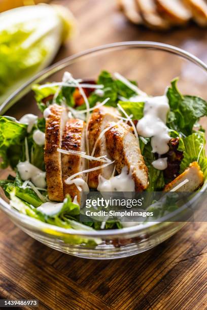 delicious caesar salad with grilled chicken slices in a glass bowl. - crunchy salad stock pictures, royalty-free photos & images