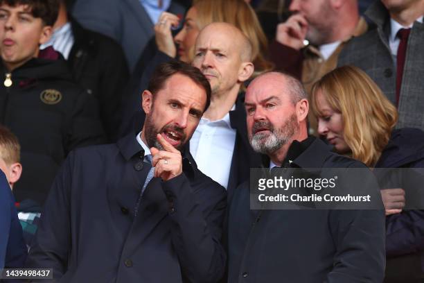Gareth Southgate, Manager of England and Steve Clarke, Manager of Scotland look on from the stands prior to the Premier League match between...