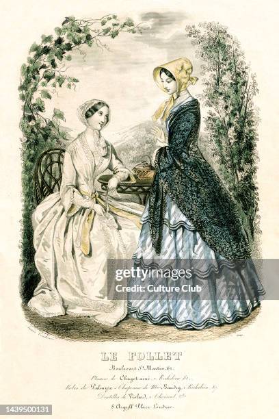 Womens fashion, mid 19th century. Two women in bonnets tied with ribbon. Full skirted dress over crinoline / bustle with tight bodice. One woman...