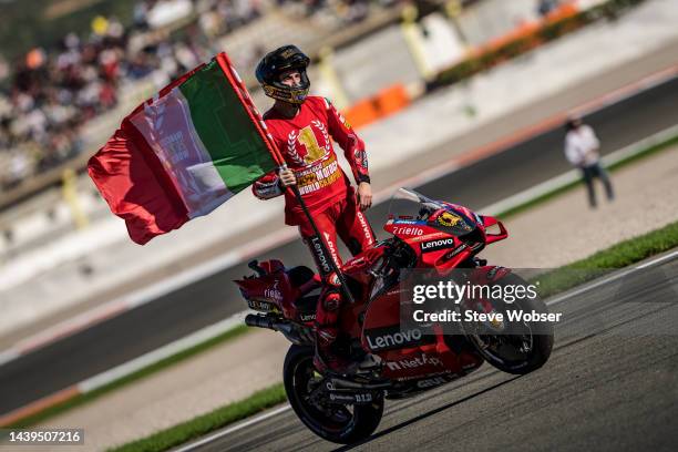 Francesco Bagnaia of Italy and Ducati Lenovo Team stands on his bike with italian flag and celebrates his MotoGP world champion title win during the...