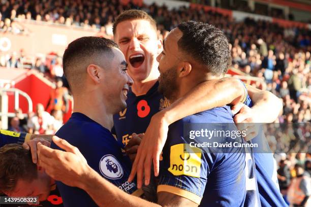 Miguel Almiron of Newcastle United celebrates with teammates after scoring their team's first goal during the Premier League match between...