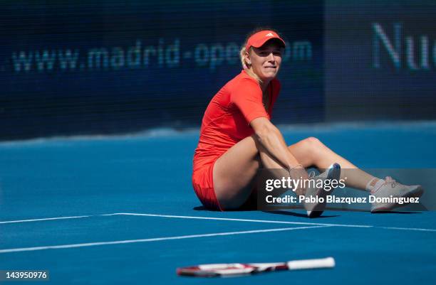 Tennis player Caroline Wozniacki of Denmark falls down during her match against Ksenia Pervak of Kazakhstan during the second day of the WTA Mutua...