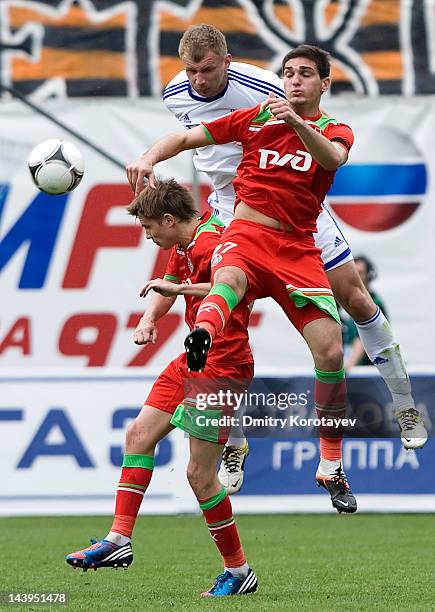 Vladimir Rykov of FC Dynamo Moscow battles for the ball with Magomed Ozdoyev and Dmitri Torbinski of FC Lokomotiv Moscow during the Russian Football...