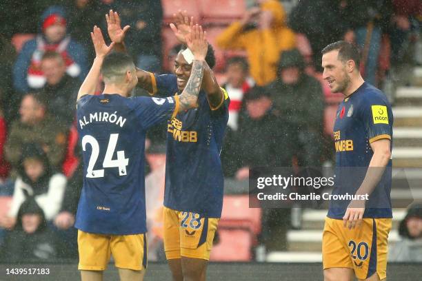 Joe Willock celebrates with Miguel Almiron of Newcastle United after scoring their team's third goal during the Premier League match between...