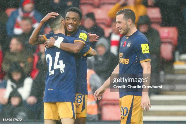 Joe Willock celebrates with Miguel Almiron of Newcastle United after scoring their team's third goal during the Premier League match between...
