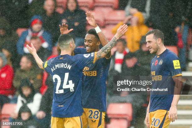 Joe Willock celebrates with Miguel Almiron of Newcastle United after scoring their team's third goal during the Premier League match between...