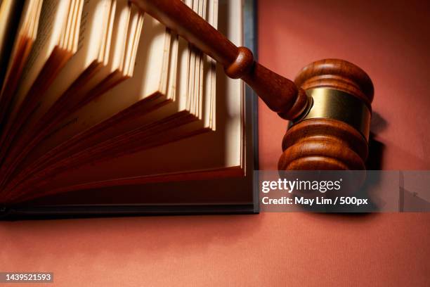 gavel hammer and book against red background - law books fotografías e imágenes de stock