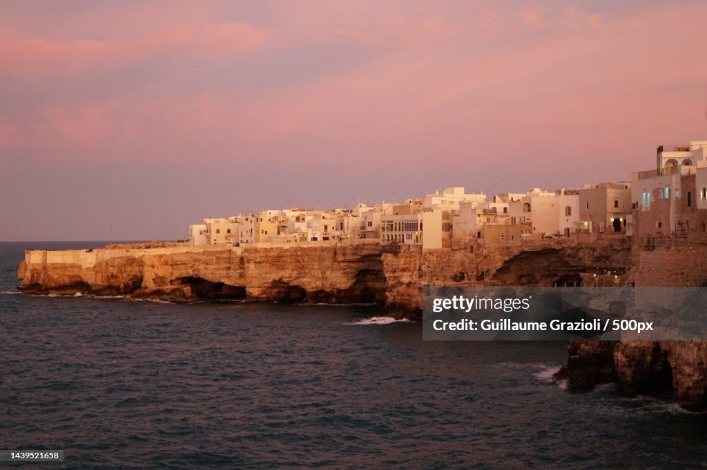 Scenic view of sea by buildings against sky during sunset,Polignano a Mare,Metropolitan City of Bari,Italy