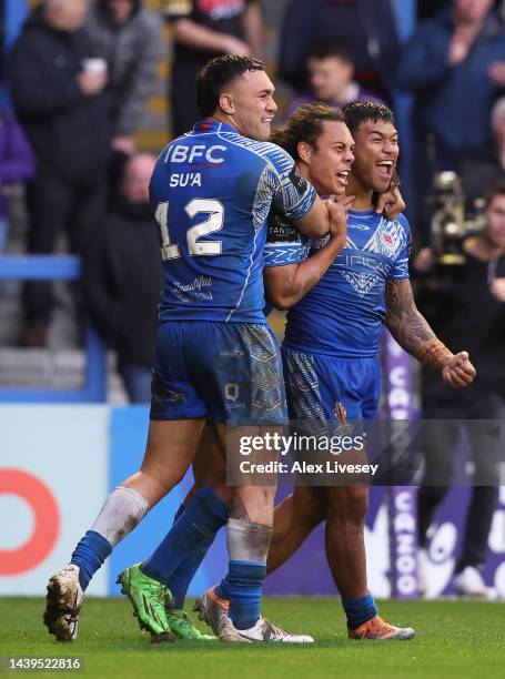 Brian To’o of Samoa celebrates their sides third try with team mates Jarome Luai and Jaydn Su’a during the Rugby League World Cup Quarter Final match...