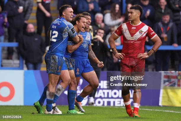 Brian To’o of Samoa celebrates their sides third try with team mates Jarome Luai and Jaydn Su’a during the Rugby League World Cup Quarter Final match...