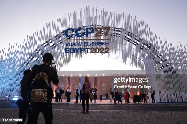 Attendees photograph one another outside the main entrance on the first day of the UNFCCC COP 27 climate conference on November 06, 2022 in Sharm El...