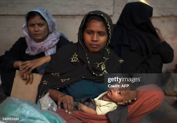 Burmese refugees from the Rohingya community, a predominantly Muslim sect in Burma, take refuge on a street near the United Nations High Commission...