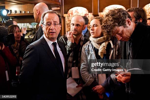 Socialist Party candidate Francois Hollande speaks to mebers of the media as he arrives at the restaurant Le Central for lunch with his partner...