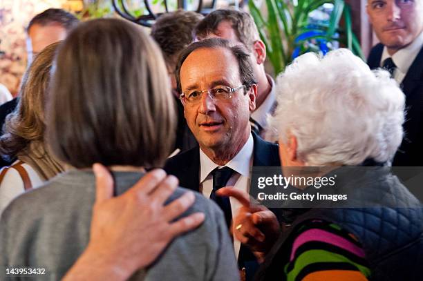 Socialist Party candidate Francois Hollande speaks with members of the public as he arrives at the restaurant Le Central for lunch with his partner...