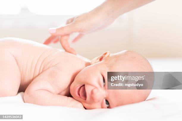 happy newborn baby having a happy time with care cream by his mother after shower - massage boy bildbanksfoton och bilder