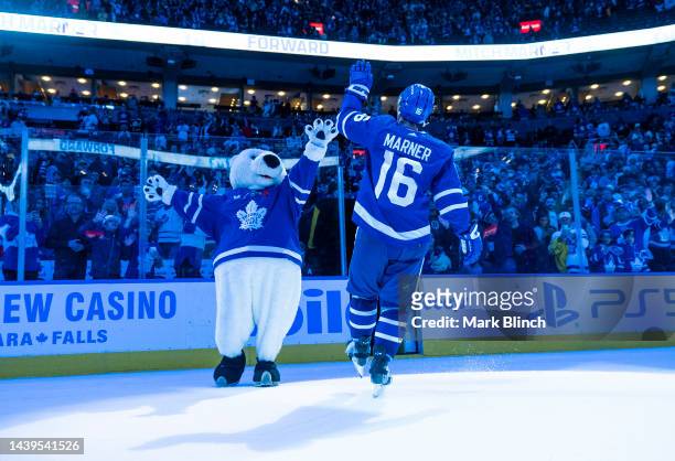 Mitchell Marner of the Toronto Maple Leafs celebrates with mascot Carlton the Bear after receiving a star of the game after defeating the Boston...