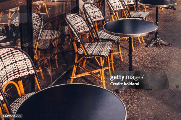 empty tables and chairs of sidewalk cafe in paris - bar paris stockfoto's en -beelden