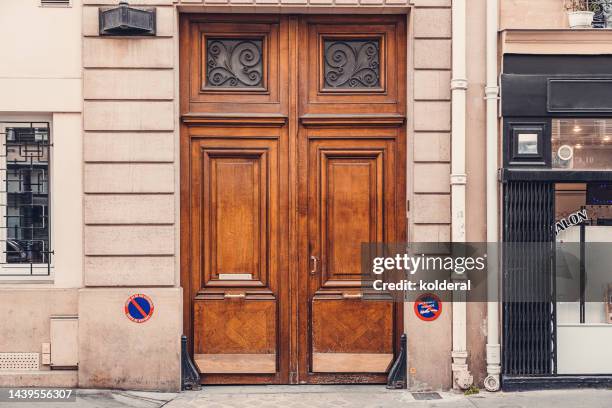 elegant wooden double doors of classic apartment building on boulevard in paris - porta de entrada imagens e fotografias de stock