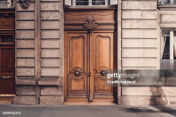 classic wooden double doors of elegant european building in paris, france - double door stock-fotos und bilder