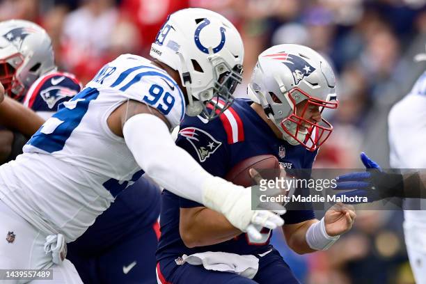Mac Jones of the New England Patriots gets tackled by DeForest Buckner of the Indianapolis Colts in the first quarter at Gillette Stadium on November...