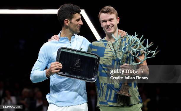 Holger Rune or Denmark celebrates with the winners trophy next to runner up Novak Djokovic of Serbia after the final during Day Seven of the Rolex...