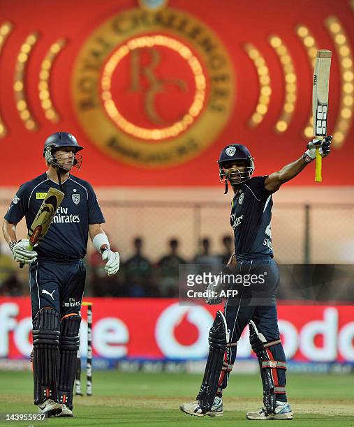 Deccan Chargers batsman Shikhar Dhawan raises his bat to celebrate 50 runs while his team mate Cameron White looks on during the IPL Twenty20 cricket...