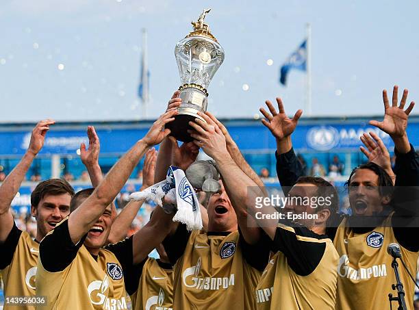 Igor Denisov, Vyacheslav Malafeev and Alexandr Kerzhakov of FC Zenit St. Petersburg hold champions cup after the Russian Football League Championship...
