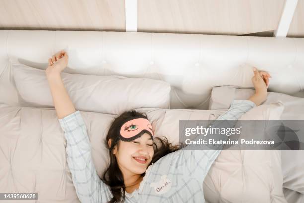 girl in pajamas wakes up in the morning and stretches after sleep - wake up happy stock pictures, royalty-free photos & images