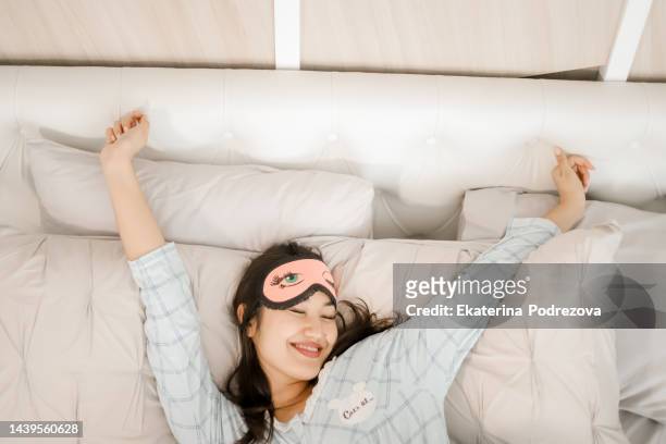 girl in pajamas wakes up in the morning and stretches after sleep - máscara de olhos imagens e fotografias de stock