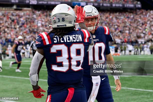 Rhamondre Stevenson and Mac Jones of the New England Patriots celebrate a touchdown in the second quarter of a game against the Indianapolis Colts at...