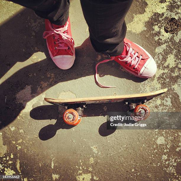 person standing next to skateboard - stringa foto e immagini stock