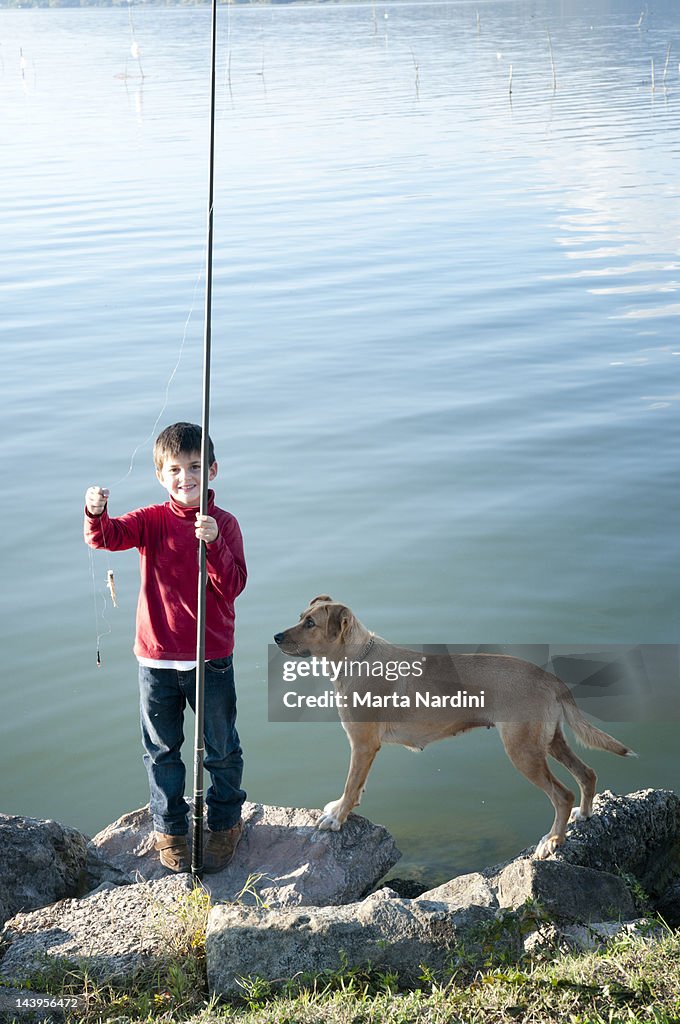 Boy fishing with dog