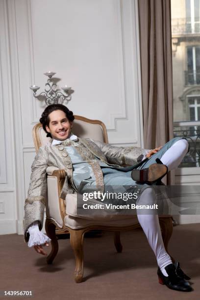 a man in 18th century costume relaxing on a chair - france costume stockfoto's en -beelden