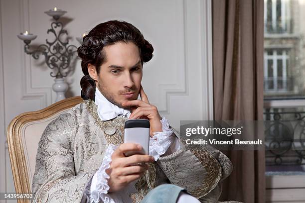 a man in 18th century costume with cell phone - roupa de época - fotografias e filmes do acervo