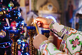Close-up of a priest lighting candles in a church. Christmas service in the Ukrainian Orthodox Church.