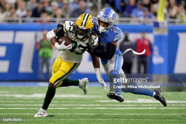 Aaron Jones of the Green Bay Packers runs with the ball as Mike Hughes of the Detroit Lions tackles him in the second half at Ford Field on November...