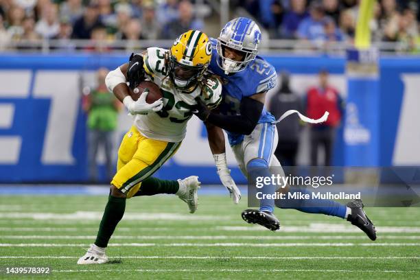 Aaron Jones of the Green Bay Packers runs with the ball as Mike Hughes of the Detroit Lions tackles him in the second half at Ford Field on November...