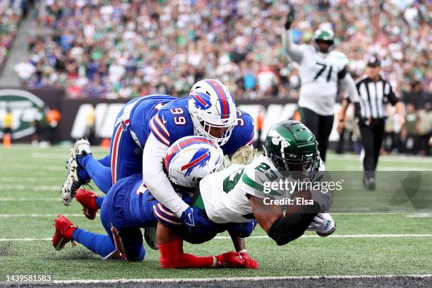 James Robinson of the New York Jets scores a touchdown as Tim Settle and Damar Hamlin of the Buffalo Bills tackle him in the third quarter at MetLife...