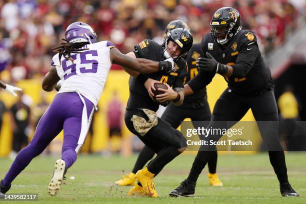 Za'Darius Smith of the Minnesota Vikings grabs the face mask of Taylor Heinicke of the Washington Commanders during the third quarter of the game at...