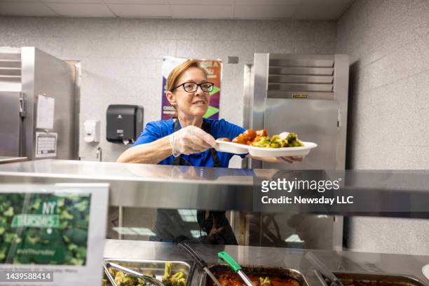 Regina Vazquez serving lunch made of local farm food at Copiague High School on Oct. 20, 2022. Copiague is participating in a plan called the 30% New...