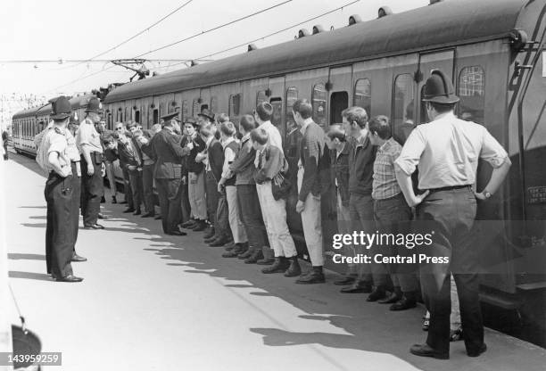 Skinheads arriving at Southend Victoria railway station are lined up to receive advice from police not to get into groups of three or more during...