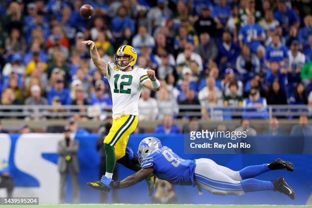 Aaron Rodgers of the Green Bay Packers throws a pass in the fourth quarter as Josh Paschal of the Detroit Lions dives for a tackle at Ford Field on...