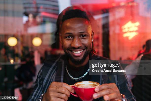 portrait of a smiley man in a modern coffee shop. - busy coffee shop stockfoto's en -beelden