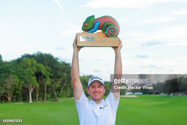 Russel Henley of United States poses with the championship trophy on the 18th hole after winning the final round of the World Wide Technology...