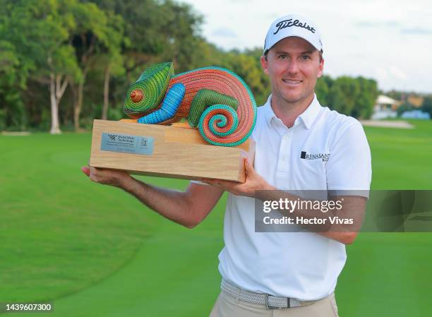 Russel Henley of United States poses with the champion trophy on the 18th hole after winning the final round of the World Wide Technology...