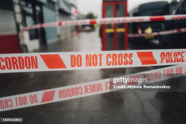 police white and red cordon tape separating the crime scene. - murder victim stock pictures, royalty-free photos & images