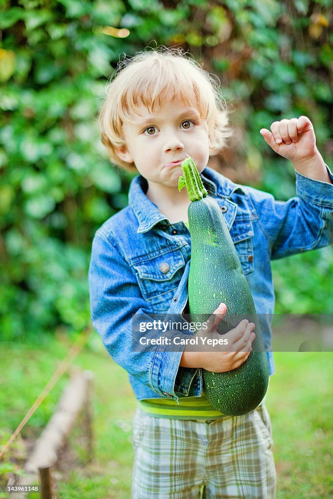 Boy holding giant zucchini