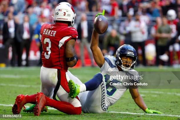 Tyler Lockett of the Seattle Seahawks reacts after scoring a touchdown whilst Budda Baker of the Arizona Cardinals looks on during the third quarter...