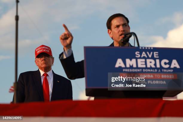 Former U.S. President Donald Trump listens as Sen. Marco Rubio speaks during a rally at the Miami-Dade County Fair and Exposition on November 6, 2022...